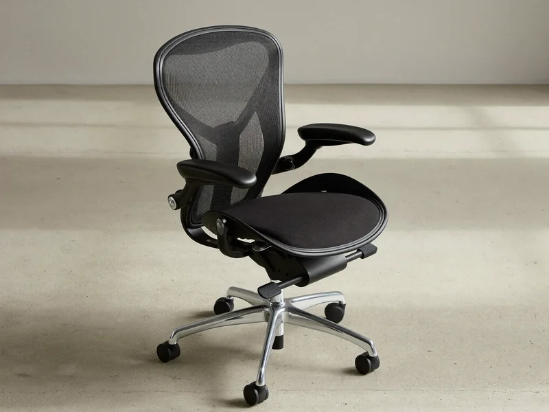 Scaun ergonomic cu spătar mesh și brațe reglabile, văzut din trei sferturi